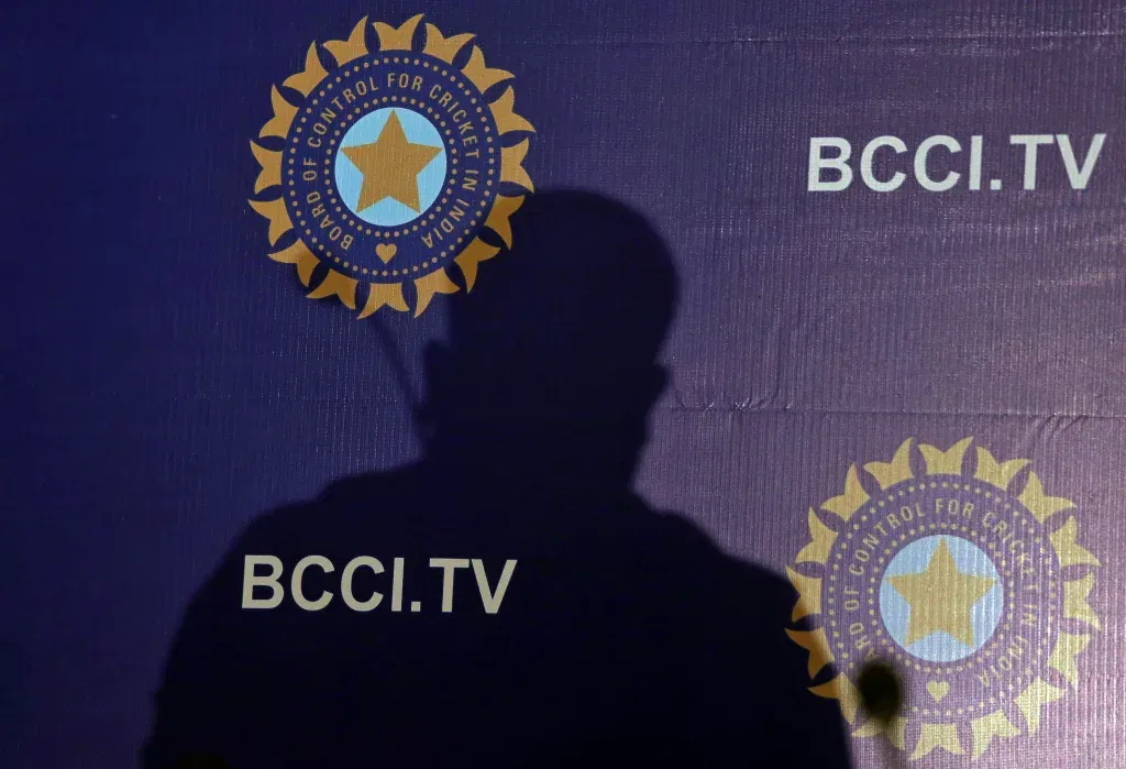 The shadow of a man falls on a backdrop with the logo of the india's cricket board bcci before the start of a news conference to announce its cricket team's coach, in mumbai,